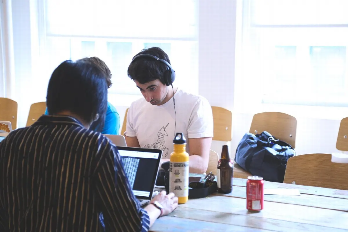 Equipe reunida em sala com laptops e documentos